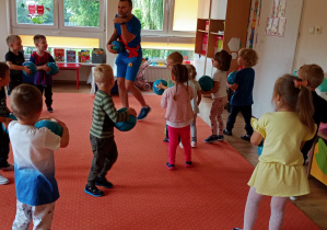 Dzieci ćwiczą z piłkami na zajęciach ruchowych
